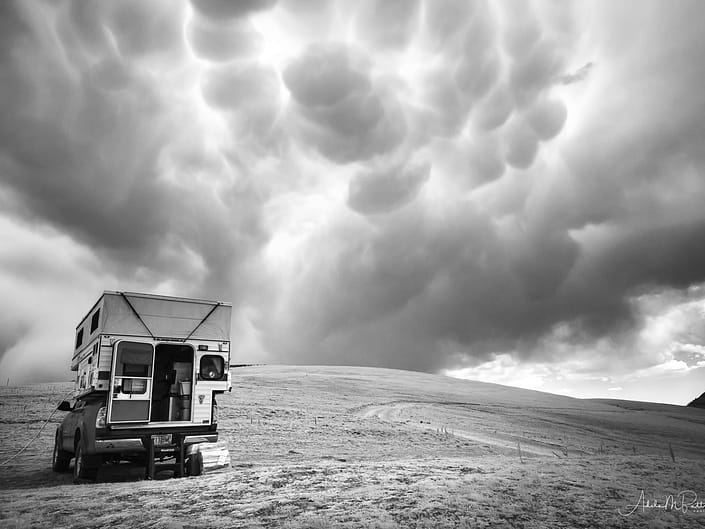 Black and white infrared photograph of a storm brewing over a camper in the Gravelly Range, Montana.